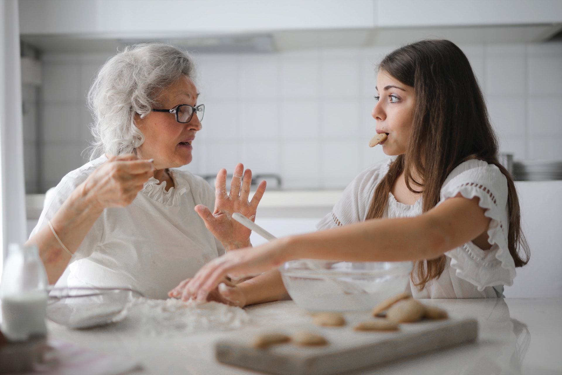 na zdjęciu babcia ucząca wnuczkę piec ciasto