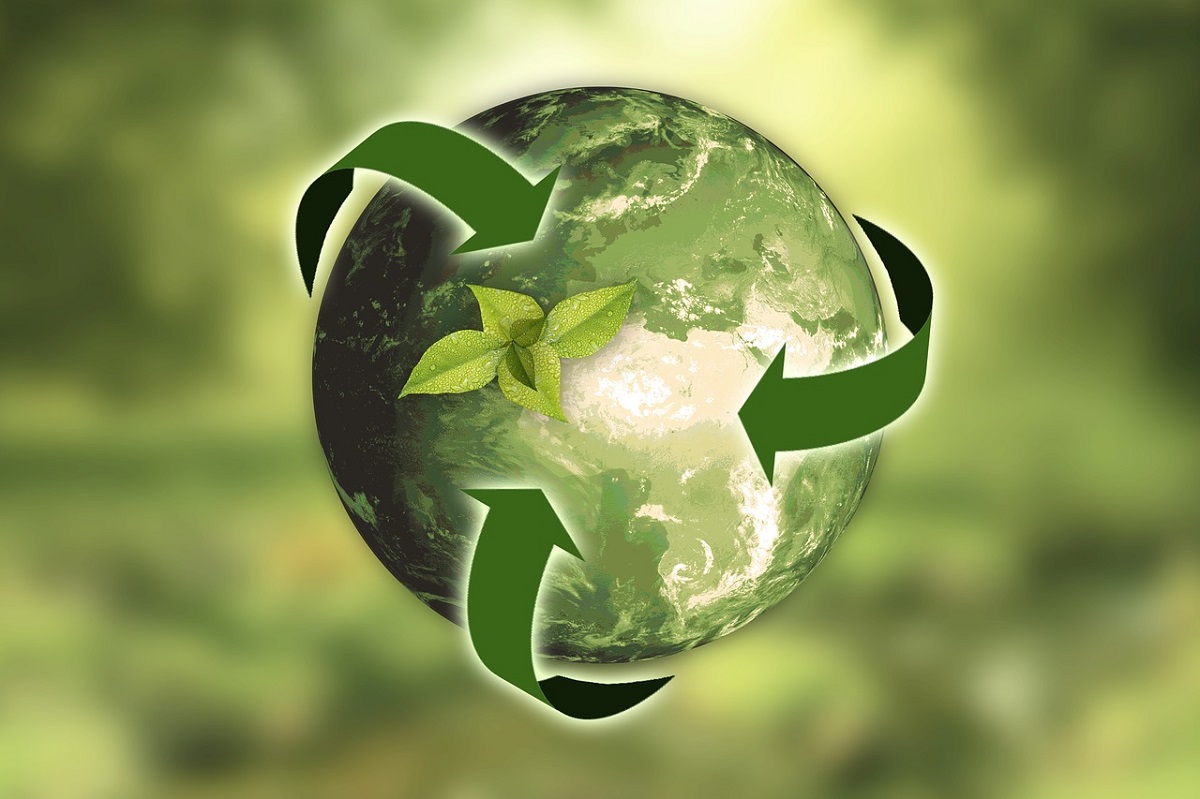 Ziemia z zielonymi strzałkami wokół niej - symbol recyklingu i natury
