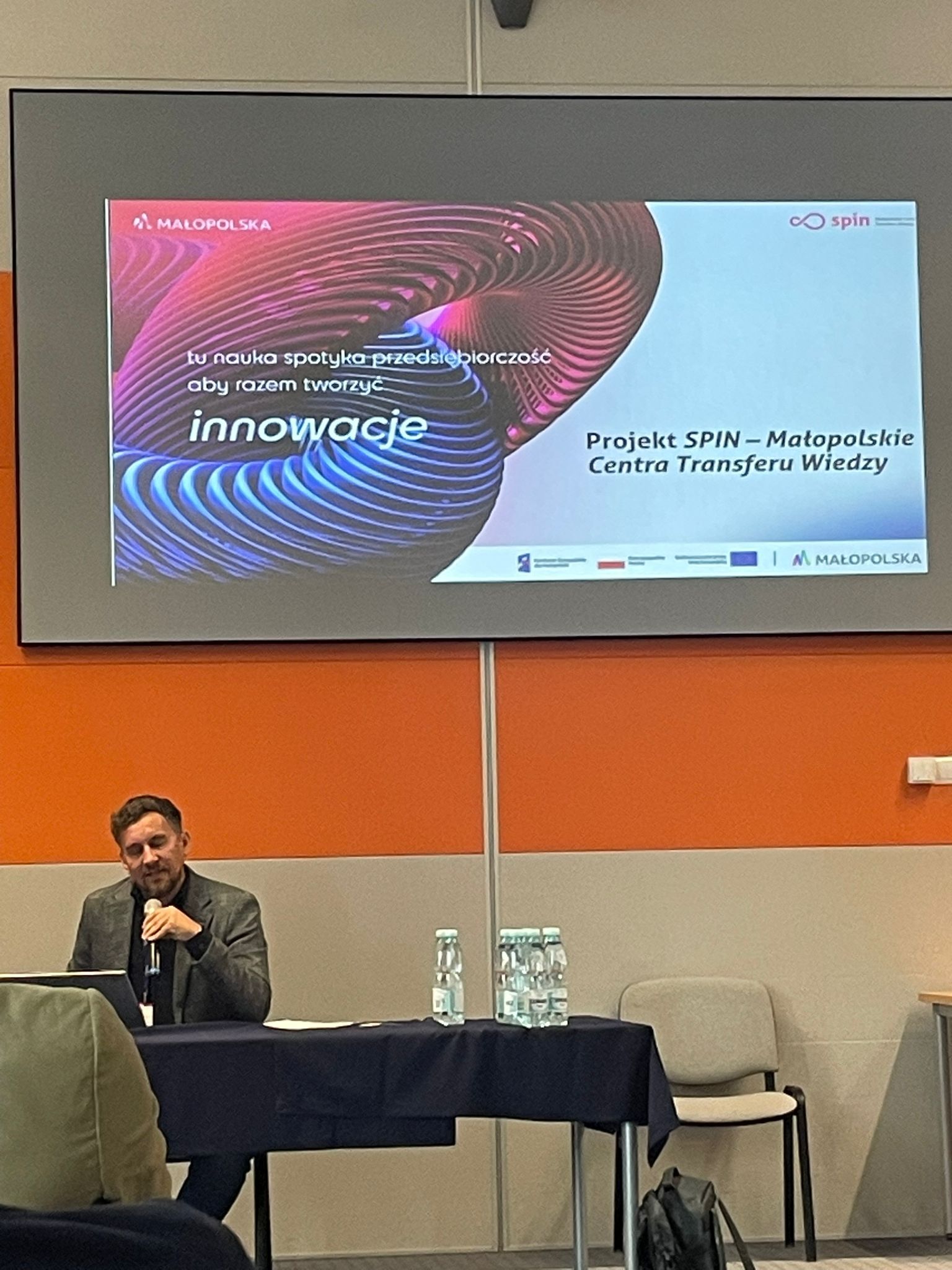 prezenter pokazuje informacje o projekcie SPIN podczas targów